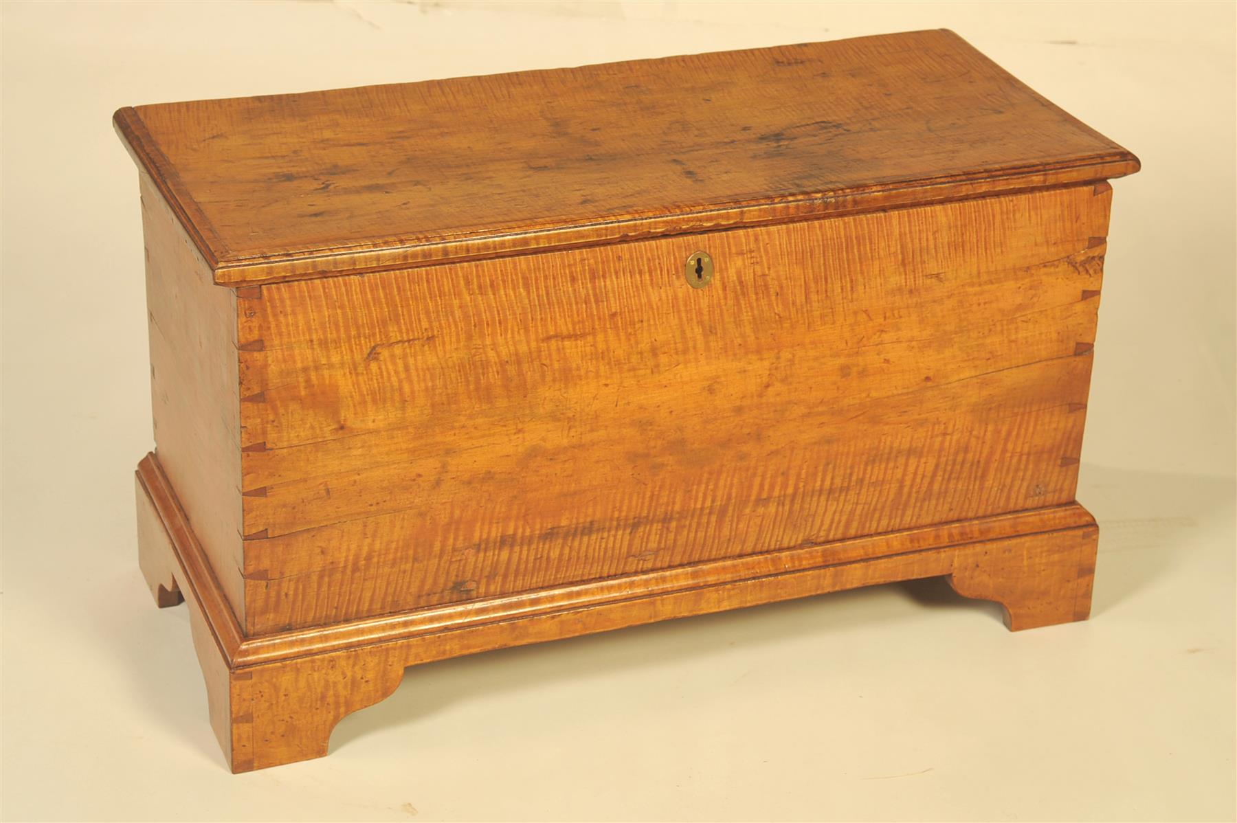 Appraisal: TIGER MAPLE BLANKET CHEST American th century Applied molding around