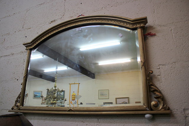 Appraisal: A GILDED WOOD AND GESSO OVERMANTLE MIRROR with an arching