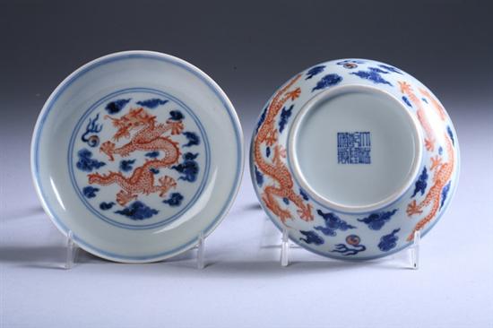 Appraisal: CHINESE COPPER RED AND BLUE PORCELAIN DRAGON SAUCERS With underglazed