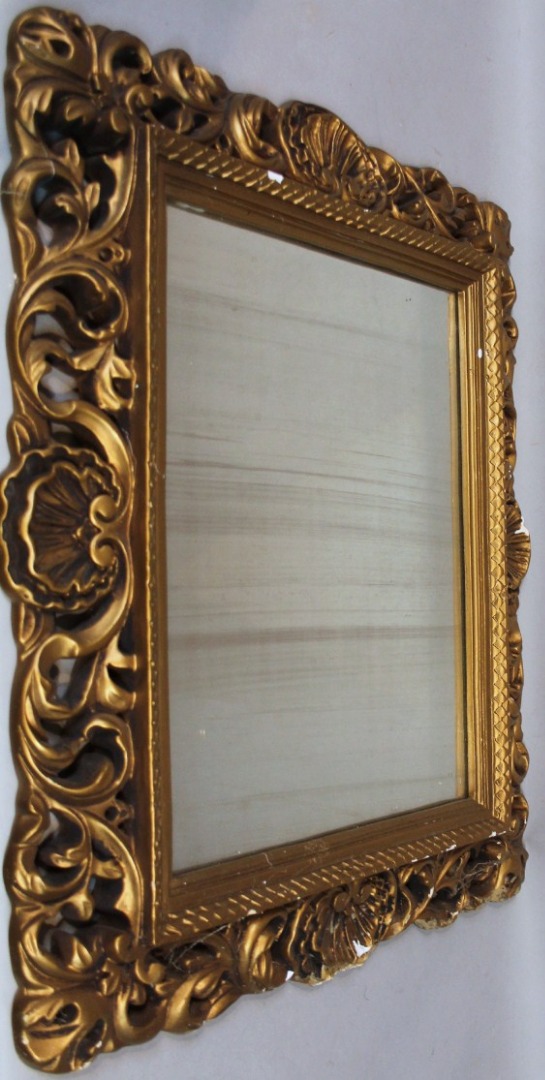 Appraisal: A rococo design mirror the outline heavily decorated with scrolls