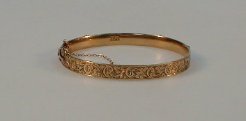 Appraisal: A hinged bangle stated gold on silver