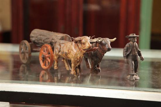 Appraisal: CAST IRON TOY A man overseeing two oxen pull a