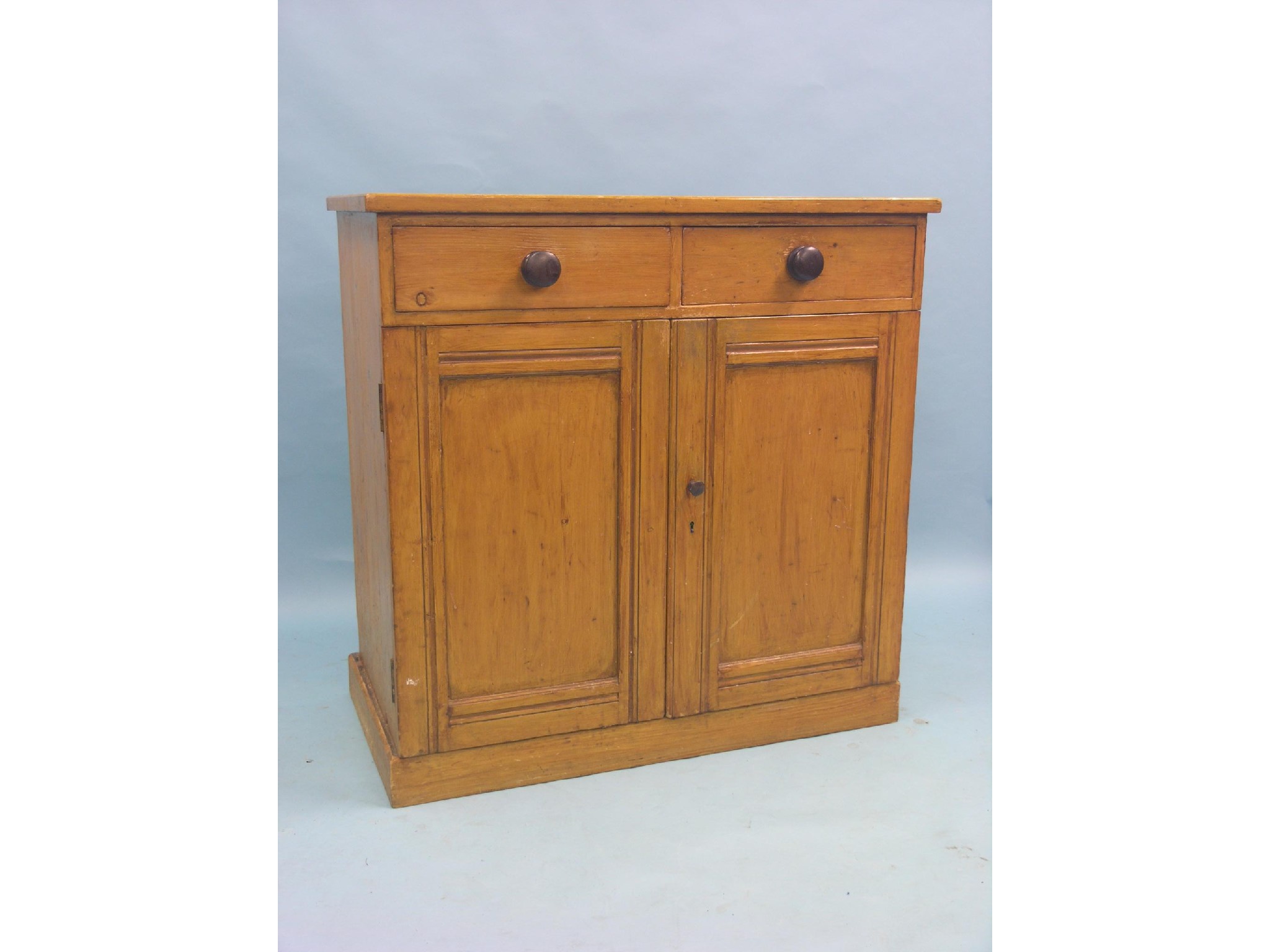 Appraisal: A Victorian stained pine cupboard two drawers with turned wood