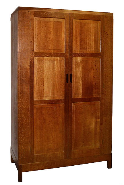 Appraisal: Cotswold School oak double wardrobecirca with panelled doors raised on