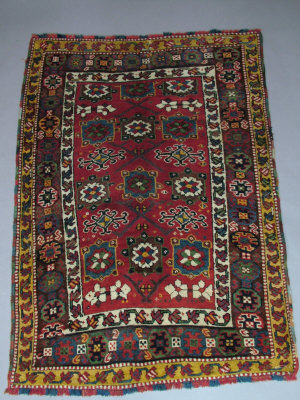 Appraisal: A Kurdish rug with flowerheads in square panels set in