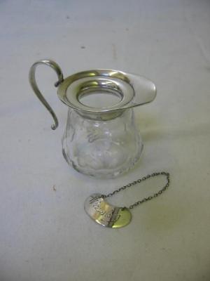 Appraisal: AN EDWARDIAN GLASS WHISKY JUG the shaped top with scroll