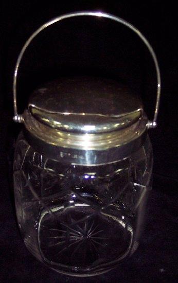 Appraisal: A cut glass biscuit barrel with silver mounts and swing