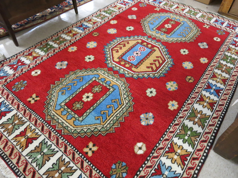 Appraisal: HAND KNOTTED ORIENTAL CARPET Indo-Kazak three geometric medallion design on