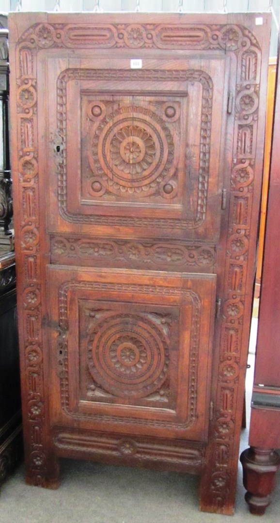 Appraisal: An th century continental chestnut two door cupboard with carved