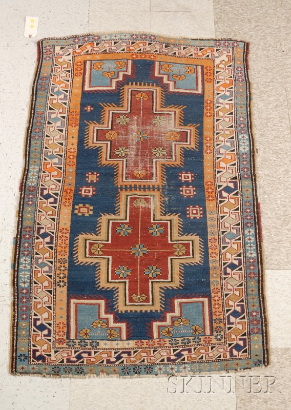 Appraisal: Caucasian Rug with two red ground medallions and blue field