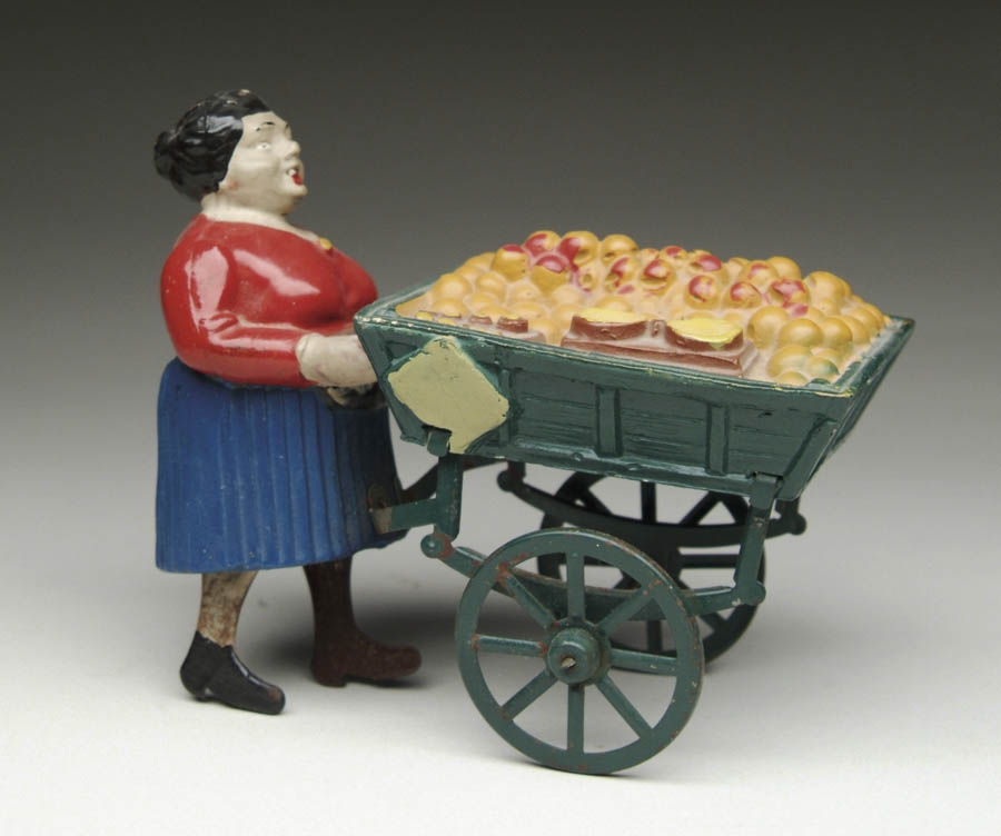 Appraisal: COMPOSITION FRUIT VENDOR WINDUP Portly lady dressed with a red