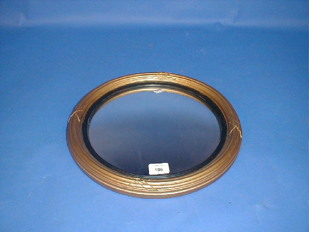 Appraisal: A circular convex wall mirror with reeded gilt frame 's