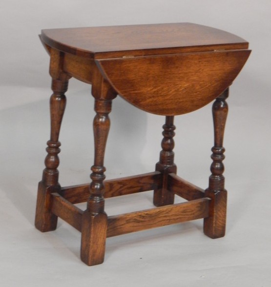 Appraisal: A reproduction oak table the oval top with two drop