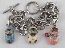 Appraisal: A white metal tests silver charm bracelet with three enamelled