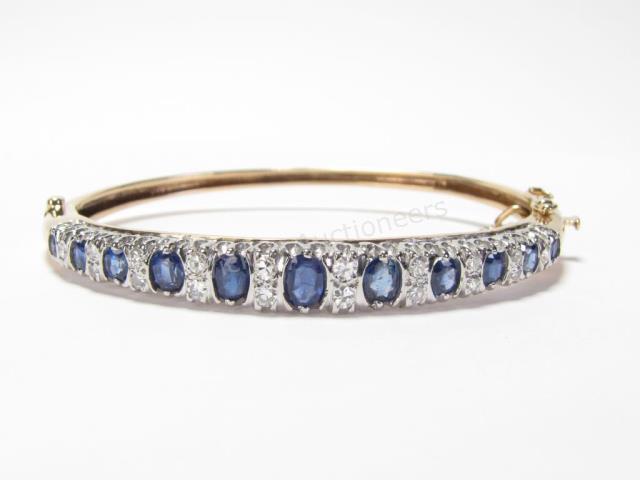 Appraisal: A K yellow gold bangle bracelet with eleven sapphires equaling