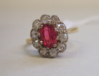 Appraisal: A synthetic ruby and diamond set oval cluster ring claw