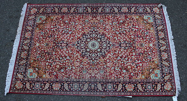 Appraisal: AN ORIENTAL SILK AND COTTON PILE RED GROUND RUG with