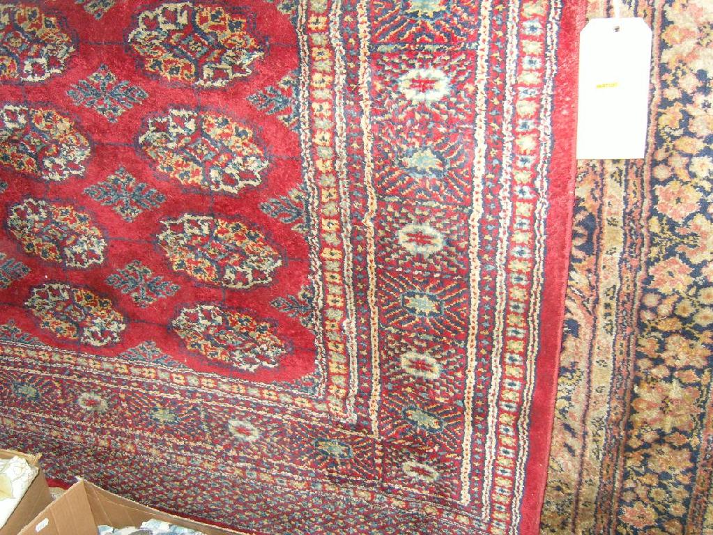 Appraisal: A red ground eastern wool rug with repeating gul motifs