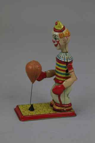 Appraisal: CLOWN WITH PUNCHING BAG Chein lithographed tin figure on stand