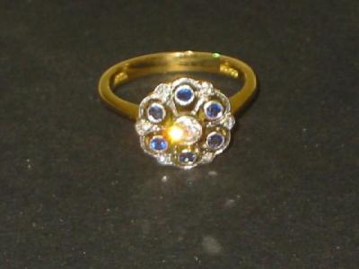 Appraisal: A SAPPHIRE AND DIAMOND CLUSTER RING the pierced rounded top