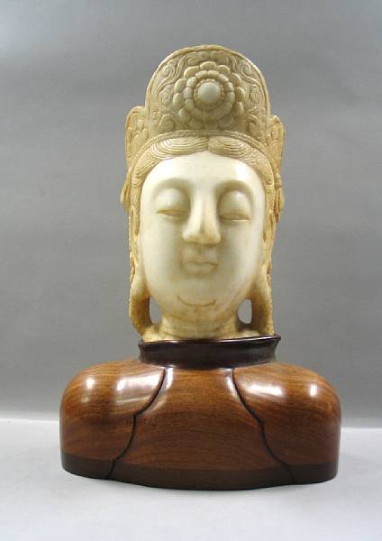 Appraisal: A white marble head of Guanyin Supported on a shoulder-shaped