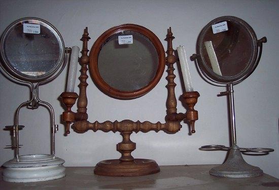 Appraisal: A turned beech framed shaving mirror the supports each fitted