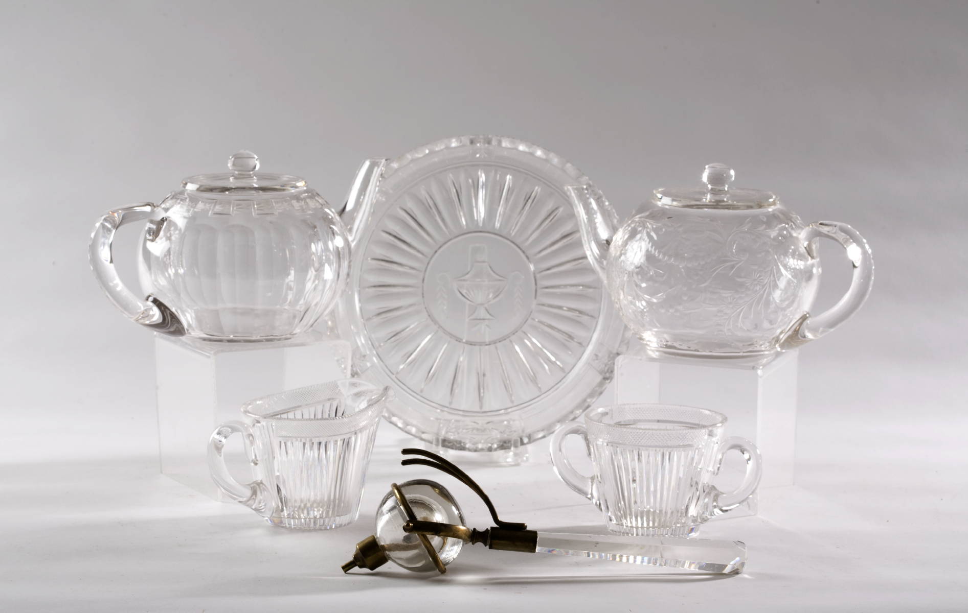 Appraisal: TWO CUT AND ENGRAVED GLASS TEAPOTS A SUGAR AND CREAMER