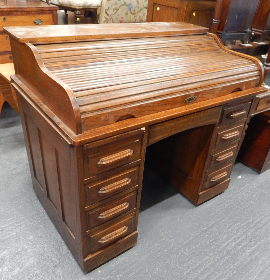 Appraisal: An oak roll top desk the tambour top enclosing a