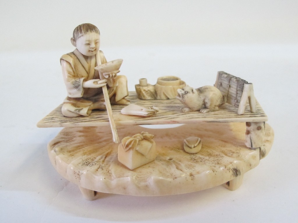 Appraisal: Japanese carved ivory figure group - man on table with