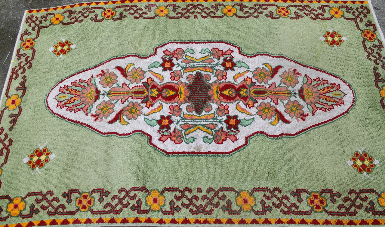 Appraisal: A modern machine woven floral patterned rug on green ground