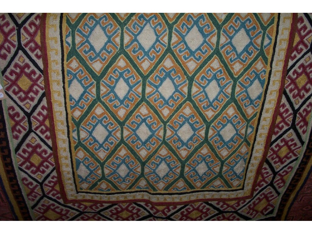 Appraisal: An Eastern chain stitch rug with polychrome hooked repeating decoration