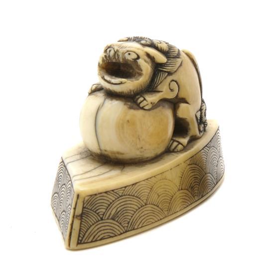 Appraisal: An Ivory Netsuke of a Buddhistic Lion carved in ivory