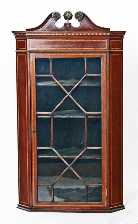 Appraisal: A Georgian mahogany corner cabinet the swan-neck pediment with brass