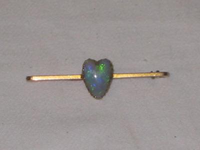 Appraisal: A BLACK OPAL BROOCH modelled as a heart claw set