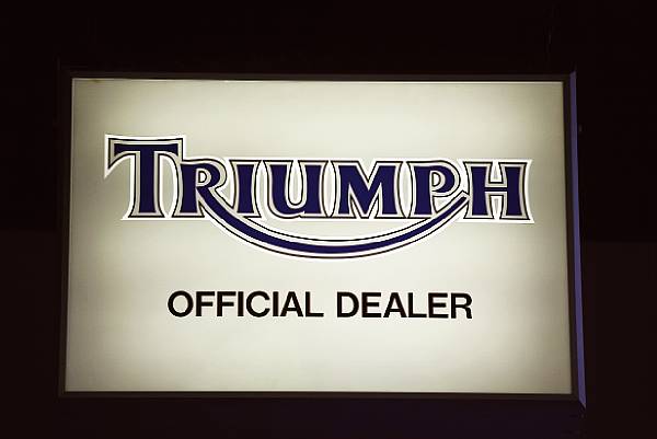 Appraisal: A Triumph illuminated display sign reading 'Triumph official dealer' double