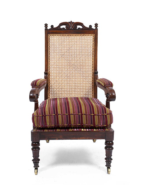 Appraisal: A VICTORIAN ROSEWOOD LIBRARY CHAIR with bergere back upholstered scrolling