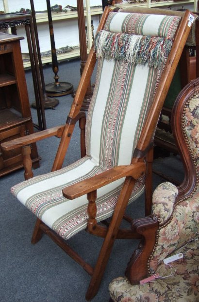 Appraisal: A th century walnut framed folding chair with turned supports