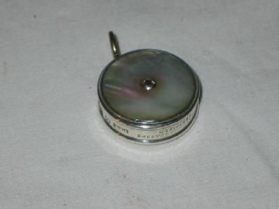 Appraisal: A VICTORIAN MOTHER OF PEARL TAPE MEASURE of circular form