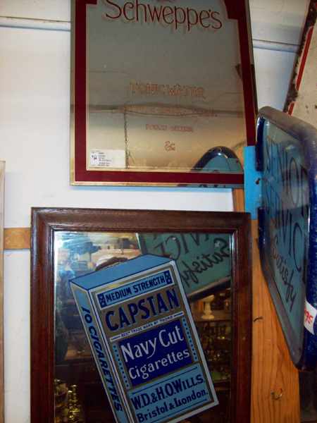 Appraisal: AN ANTIQUE CAPSTAN FRAMED MIRROR AND A SCHWEPPES MIRROR