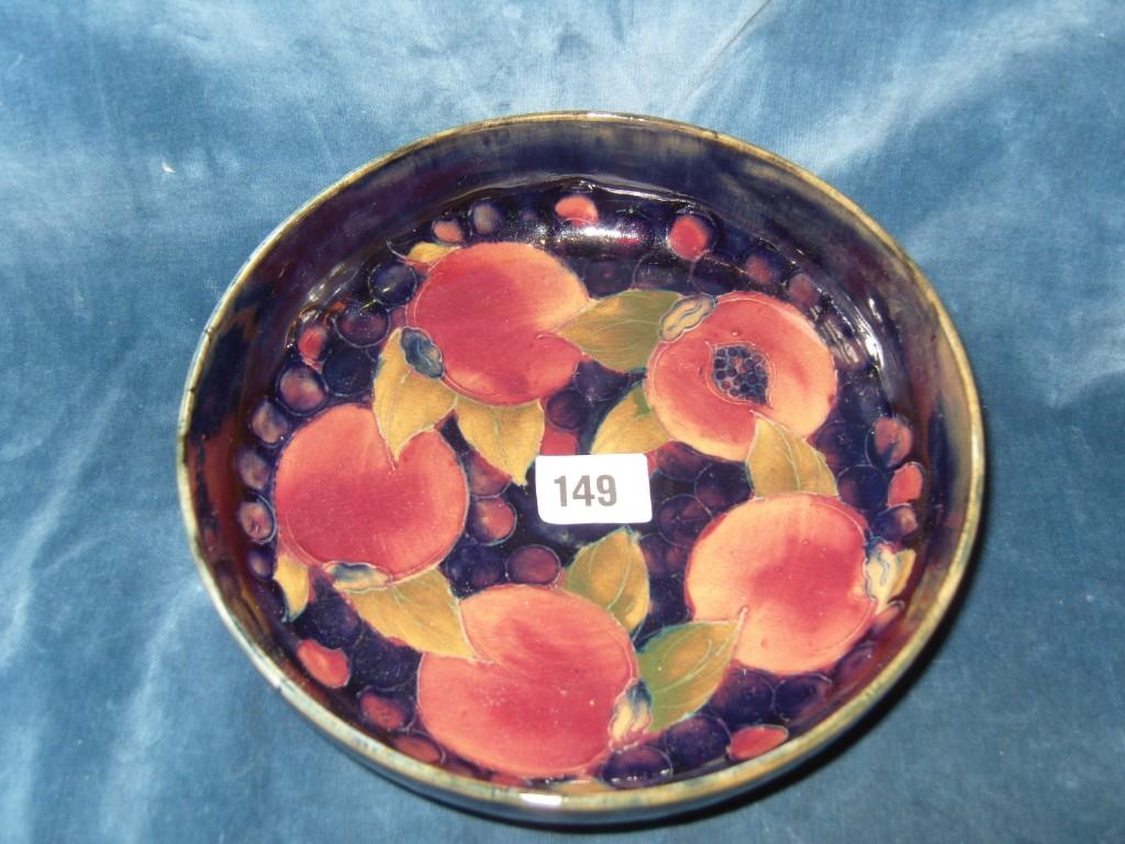 Appraisal: A Moorcroft blue ground bowl with painted and raised pomegranate