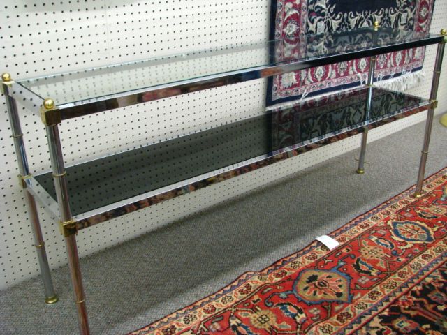 Appraisal: Chrome brass and glass sofa table two-tiered chrome frame with