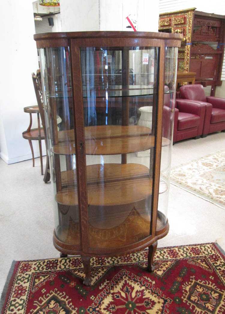 Appraisal: AN OAK AND CURVED GLASS CHINA CABINET American c the