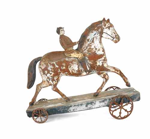 Appraisal: Large painted tin horse and rider pull toy th c