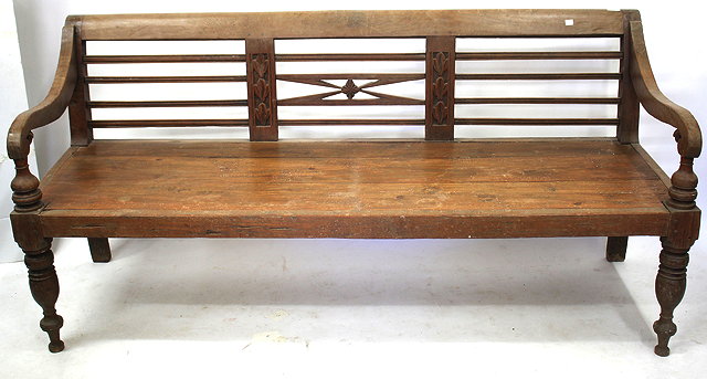 Appraisal: AN ANTIQUE TEAK BENCH or daybed with scrolling arms turned