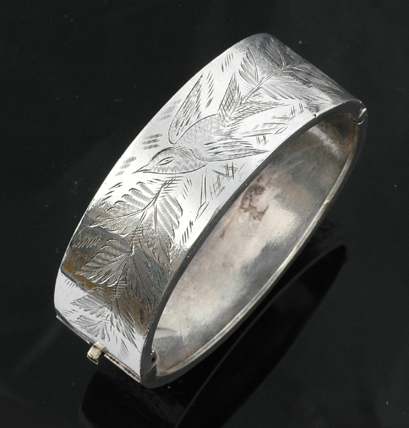 Appraisal: An antique silver cuff The hinged bangle with engraved bird