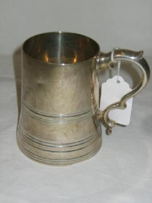 Appraisal: A TANKARD of tapering form with moulded fillet double scroll