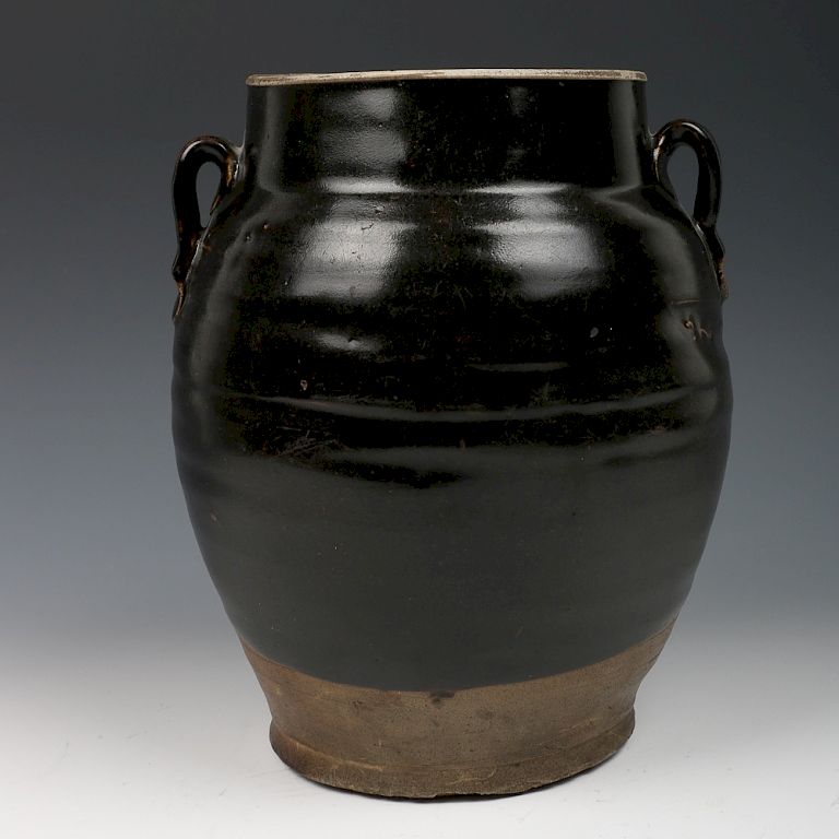 Appraisal: CHINESE BLACK GLAZED POTTERY JAR Of pear shape body supported