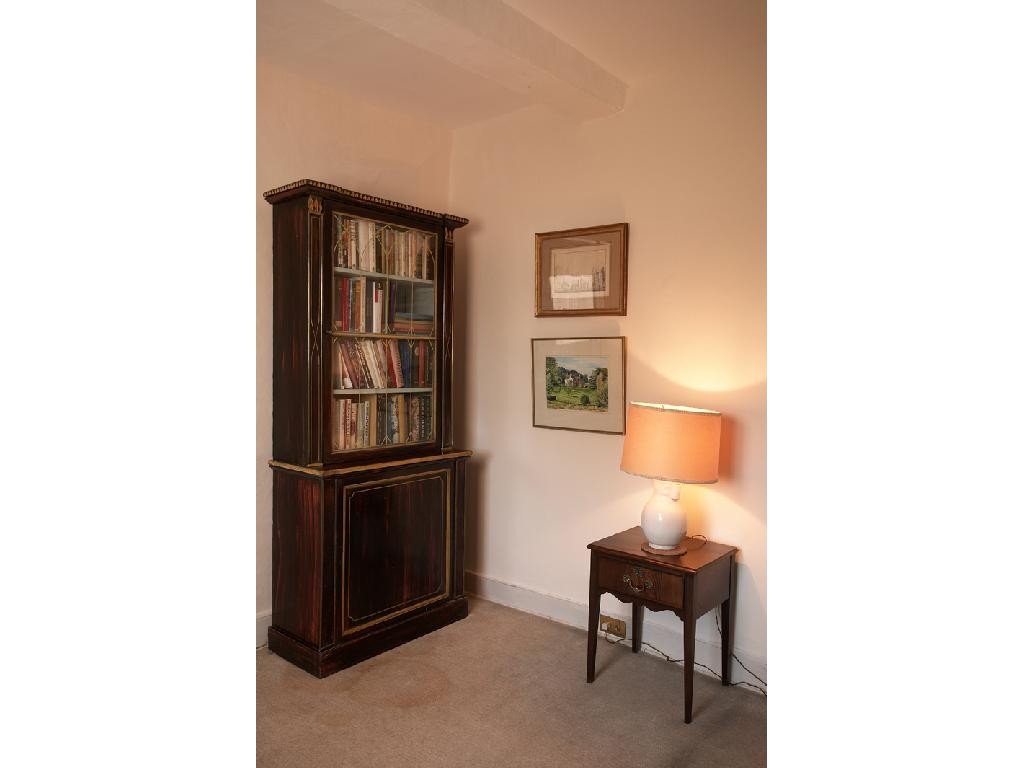 Appraisal: A REGENCY STYLE SIMULATED ROSEWOOD AND PARCEL GILT BOOKCASE the