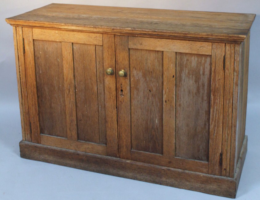 Appraisal: A late thC plank top oak cupboard centred by two