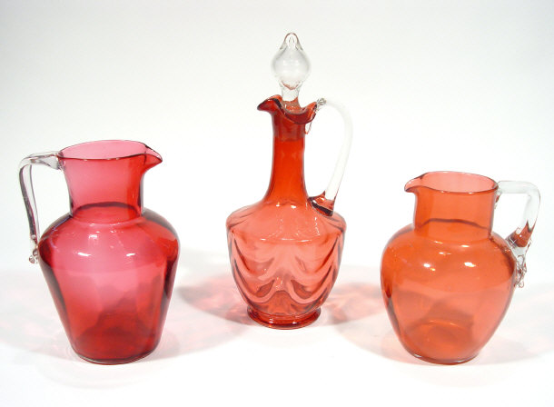 Appraisal: Cranberry glass ewer with stopper and two cranberry glass jugs